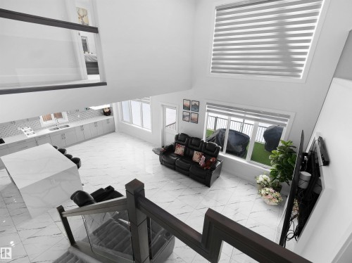 Open-concept interior featuring high ceilings, white tile flooring, and a contemporary kitchen - 1208 25 St Nw, Edmonton, AB - Indoor Photo Showing Other Room