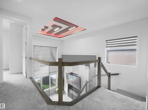 Contemporary ceiling feature with integrated lighting, glass railing system, light gray carpeting, and white trim - 1208 25 St Nw, Edmonton, AB - Indoor Photo Showing Other Room