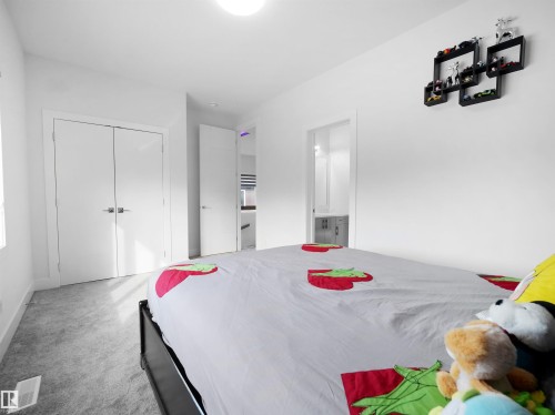 Bedroom featuring light gray carpeting, crisp white walls, and a recessed ceiling light - 1208 25 St Nw, Edmonton, AB - Indoor Photo Showing Bedroom