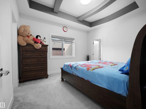 Recessed ceiling with grey accent beams, light grey carpeting, white walls, and a window with horizontal blinds - 1208 25 St Nw, Edmonton, AB - Indoor Photo Showing Bedroom