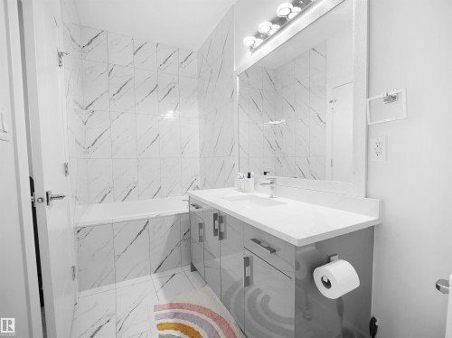 Modern bathroom featuring a single vanity with a white countertop and gloss gray cabinetry - 1208 25 St Nw, Edmonton, AB - Indoor Photo Showing Bathroom