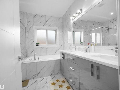 Full bathroom featuring a built-in tub, white marble-look wall and floor tile, a dual vanity with a white countertop and grey cabinetry, and a glass-enclosed shower - 1208 25 St Nw, Edmonton, AB - Indoor Photo Showing Bathroom