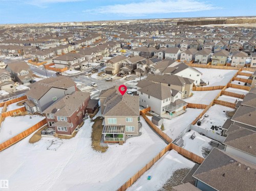 Contemporary two-story residence featuring a covered rear deck, fenced yard, and a shingled roof - 1208 25 St Nw, Edmonton, AB - Outdoor With View