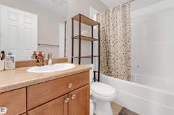 Vanity featuring an integrated sink, laminate countertop, and wood-finish cabinetry with clear knob hardware - 
