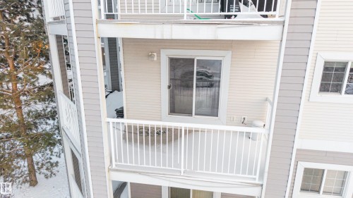 Balcony with white metal railing and sliding glass door - 201 4403 23 Street, Edmonton, AB - Outdoor With Exterior