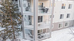 Multi-story residential building featuring private balconies with white railings and sliding glass doors - 