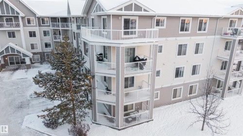 Multi-story residential building with light-colored siding and white trim - 201 4403 23 Street, Edmonton, AB - Outdoor With Balcony With Facade