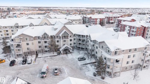 Multi-story residential building featuring a light-toned exterior with gabled roofs - 201 4403 23 Street, Edmonton, AB - Outdoor With Facade