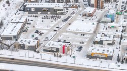 Commercial development featuring multiple buildings with snow-covered rooftops and surrounding grounds - 