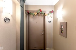 Entry door with wall-mounted sconces and a recessed fire extinguisher cabinet - 