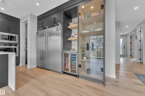 Modern kitchen featuring light wood-finish flooring and dark cabinetry - 5722 Kootook Way, Edmonton, AB - Indoor Photo Showing Kitchen