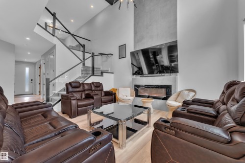 Living space featuring a tall ceiling and a contemporary fireplace - 5722 Kootook Way, Edmonton, AB - Indoor Photo Showing Living Room With Fireplace
