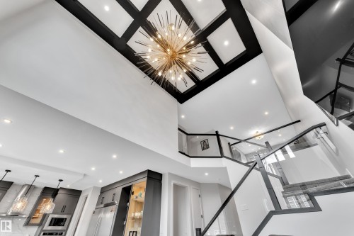 Grand foyer featuring a two-story ceiling with coffered detailing and a statement chandelier - 5722 Kootook Way, Edmonton, AB - Indoor Photo Showing Other Room