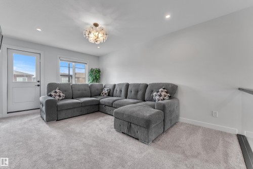 Spacious room featuring light gray carpeting and white walls - 5722 Kootook Way, Edmonton, AB - Indoor Photo Showing Living Room