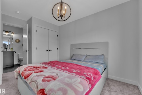 Bedroom featuring a contemporary chandelier, light gray walls, and carpet flooring - 5722 Kootook Way, Edmonton, AB - Indoor Photo Showing Bedroom