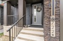 Contemporary exterior featuring stacked stone accents, dark siding, and a modern grey entry door with vertical window panels - 5722 Kootook Way, Edmonton, AB  - Outdoor 