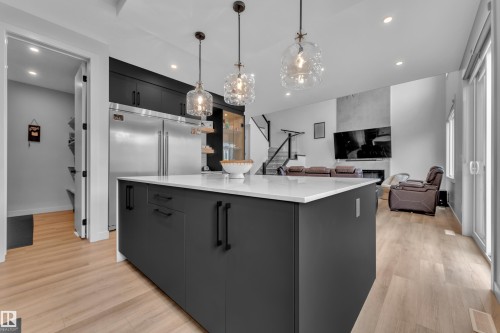 Modern kitchen island with a white countertop and dark cabinetry - 5722 Kootook Way, Edmonton, AB - Indoor Photo Showing Kitchen With Upgraded Kitchen