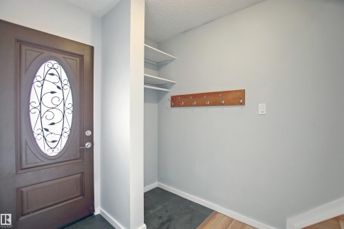 Entryway featuring a dark wood door with an oval decorative glass insert - 11 14120 80 Street, Edmonton, AB - Indoor Photo Showing Other Room