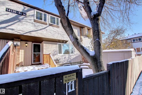 Townhome exterior featuring a stucco upper facade and vertical siding lower facade - 11 14120 80 Street, Edmonton, AB - Outdoor