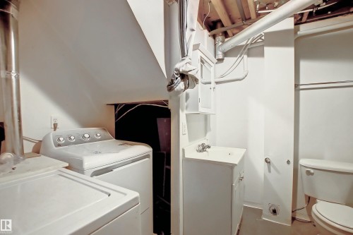Dedicated laundry area featuring a top-load washing machine, utility sink with vanity, and a toilet - 11 14120 80 Street, Edmonton, AB - Indoor Photo Showing Laundry Room