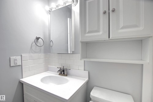 Bathroom vanity with integrated sink, subway tile backsplash, and mirrored medicine cabinet - 11 14120 80 Street, Edmonton, AB - Indoor Photo Showing Bathroom