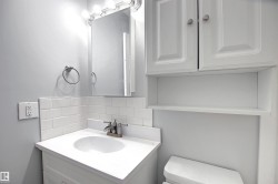 Bathroom vanity with integrated sink, subway tile backsplash, and mirrored medicine cabinet - 