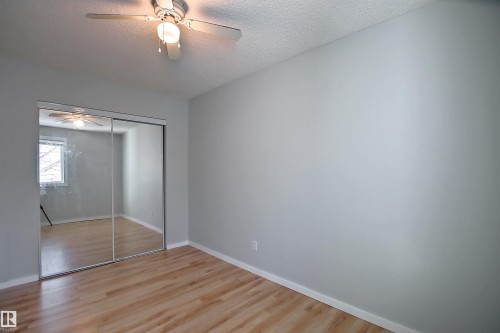 Room with wood-finish flooring, light gray walls, and white trim - 11 14120 80 Street, Edmonton, AB - Indoor Photo Showing Other Room