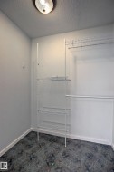 Dedicated closet space featuring a ceiling-mounted light fixture, white wire shelving units, and a hanging rod - 
