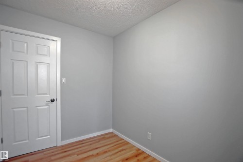 Light gray painted walls with wood-finish flooring - 11 14120 80 Street, Edmonton, AB - Indoor Photo Showing Other Room