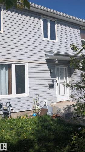 Light gray vinyl siding exterior with white window frames and a storm door - 4 Amberly Crest, Edmonton, AB - Outdoor With Exterior