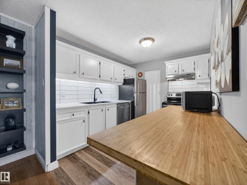 Kitchen featuring white cabinetry, a white subway tile backsplash, and a black sink with a matte black faucet - 165 2703 79 Street, Edmonton, AB - Indoor Photo Showing Kitchen