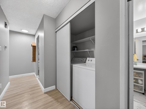 Hallway featuring wood-finish flooring, light gray walls, and recessed lighting - 165 2703 79 Street, Edmonton, AB - Indoor Photo Showing Laundry Room