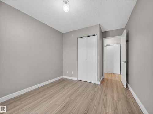 Room featuring wood-finish flooring, light gray walls, a popcorn ceiling, and a flush mount light fixture - 165 2703 79 Street, Edmonton, AB - Indoor Photo Showing Other Room