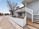 Multi-level townhouse exterior featuring light-colored siding and a white picket fence - 165 2703 79 Street, Edmonton, AB  - Outdoor 