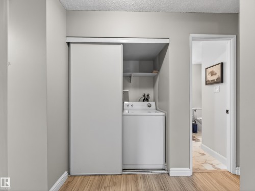 Integrated laundry closet with white appliances and sliding panel doors - 165 2703 79 Street, Edmonton, AB - Indoor