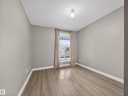 Neutral wall tones complement wood-finish flooring - 165 2703 79 Street, Edmonton, AB - Indoor Photo Showing Other Room