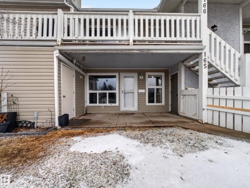 Ground-level entry featuring light-colored siding and a covered patio area - 165 2703 79 Street, Edmonton, AB - Outdoor