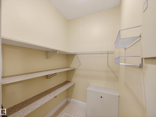 Utility space with tile flooring, built-in shelving, and a textured ceiling - 165 2703 79 Street, Edmonton, AB - Indoor With Storage
