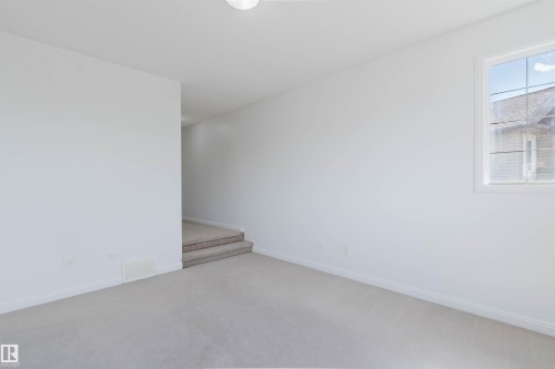 Carpeted room with white walls, baseboards, and a window - 1951 120 Street, Edmonton, AB - Indoor Photo Showing Other Room