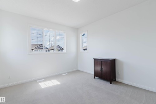 Bright room featuring neutral carpeting and white painted walls - 1951 120 Street, Edmonton, AB - Indoor Photo Showing Other Room
