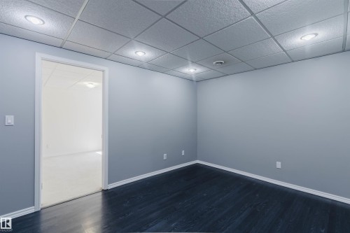 Room featuring dark wood-finish flooring, light gray painted walls, and a drop ceiling with recessed lighting - 1951 120 Street, Edmonton, AB - Indoor Photo Showing Other Room