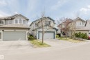 Contemporary suburban residence featuring a two-car garage, concrete driveway, and light grey siding - 1951 120 Street, Edmonton, AB  - Outdoor With Facade 