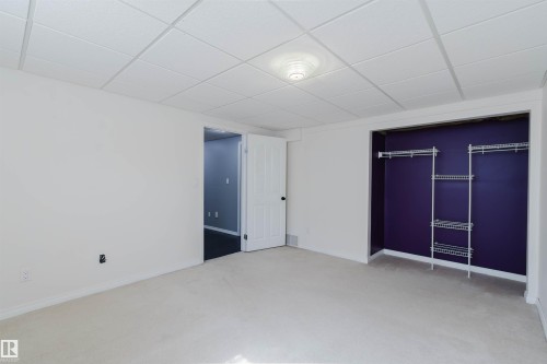 Carpeted room with a wire rack closet system, drop ceiling, and flush mount lighting - 1951 120 Street, Edmonton, AB - Indoor Photo Showing Other Room