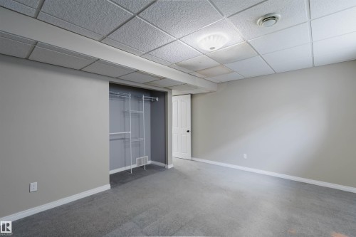 Carpeted room with drop ceiling, recessed lighting, and a closet with wire shelving - 1951 120 Street, Edmonton, AB - Indoor