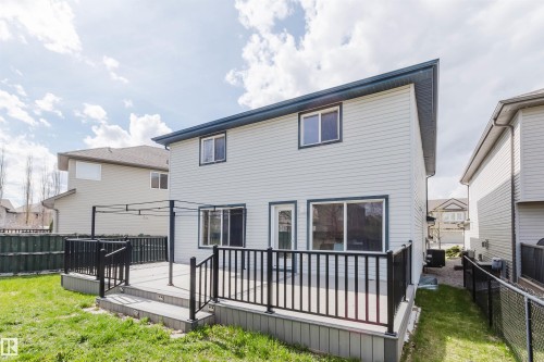 Two-story siding exterior with a dark-trimmed roofline, featuring a spacious composite deck with black railings and integrated stair lighting - 1951 120 Street, Edmonton, AB - Outdoor With Deck Patio Veranda With Exterior