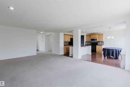 Open concept main living area featuring recessed lighting, a neutral color palette, and a kitchen with wood cabinetry - 1951 120 Street, Edmonton, AB - Indoor Photo Showing Kitchen