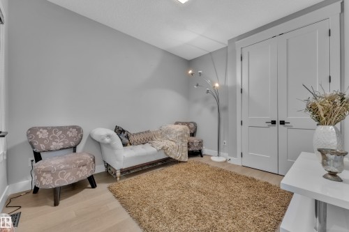 Recessed ceiling lighting illuminates a room featuring light wood-finish flooring, light grey wall paint, and white baseboards - 8025 174A Avenue, Edmonton, AB - Indoor