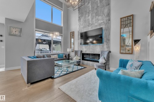 Bright living space featuring a two-story vaulted ceiling and expansive windows - 8025 174A Avenue, Edmonton, AB - Indoor Photo Showing Living Room With Fireplace