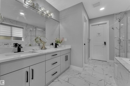 Modern bathroom featuring a dual vanity with light gray cabinetry, white countertops, and matte black fixtures - 8025 174A Avenue, Edmonton, AB - Indoor Photo Showing Bathroom
