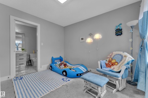 Carpeted room with light gray walls and an open doorway revealing a tiled bathroom - 8025 174A Avenue, Edmonton, AB - Indoor